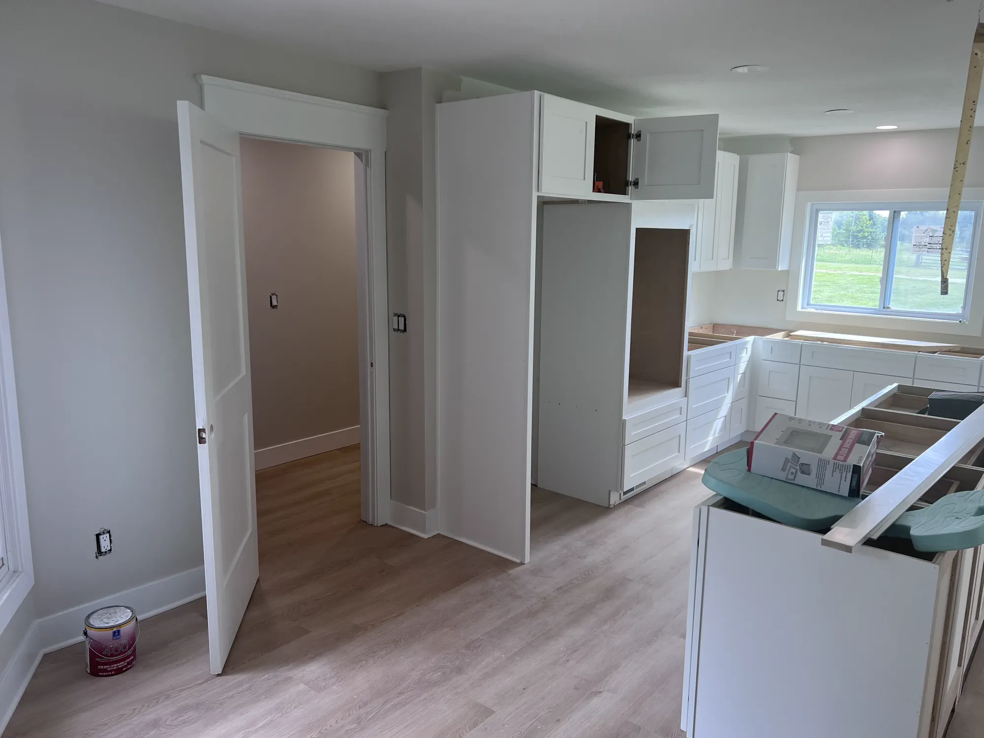An unfinished area of the house with flooring, supplies, and renovation work underway